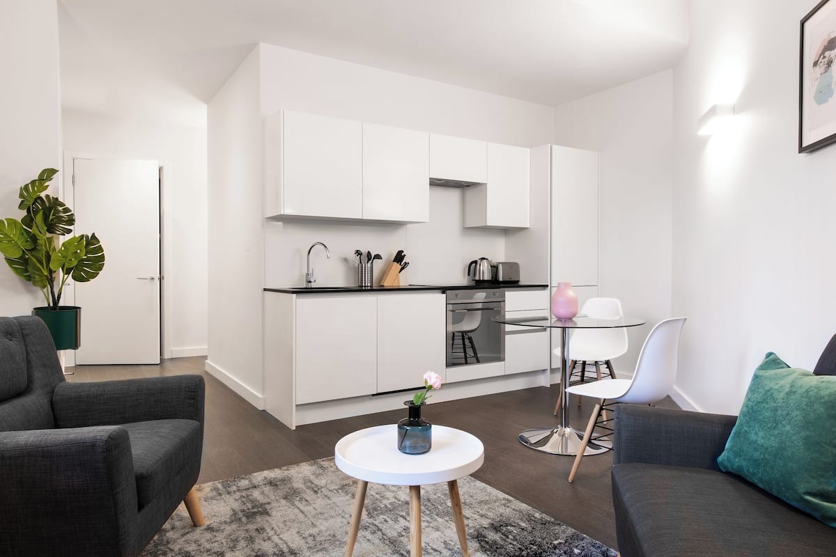A modern apartment with a kitchen, dining area, and living room.