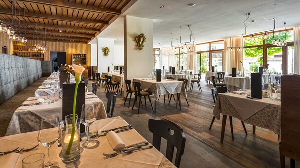 Un restaurante con varias mesas dispuestas para comer, que incluye una combinación de mesas redondas y rectangulares.