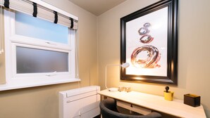 A small, well-lit room with a desk, chair, radiator, and a framed artwork on the wall. -  The Warwick by Nestor (London)