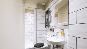 A bathroom with a toilet, sink, and a towel rack. -  The Warwick by Nestor (London)