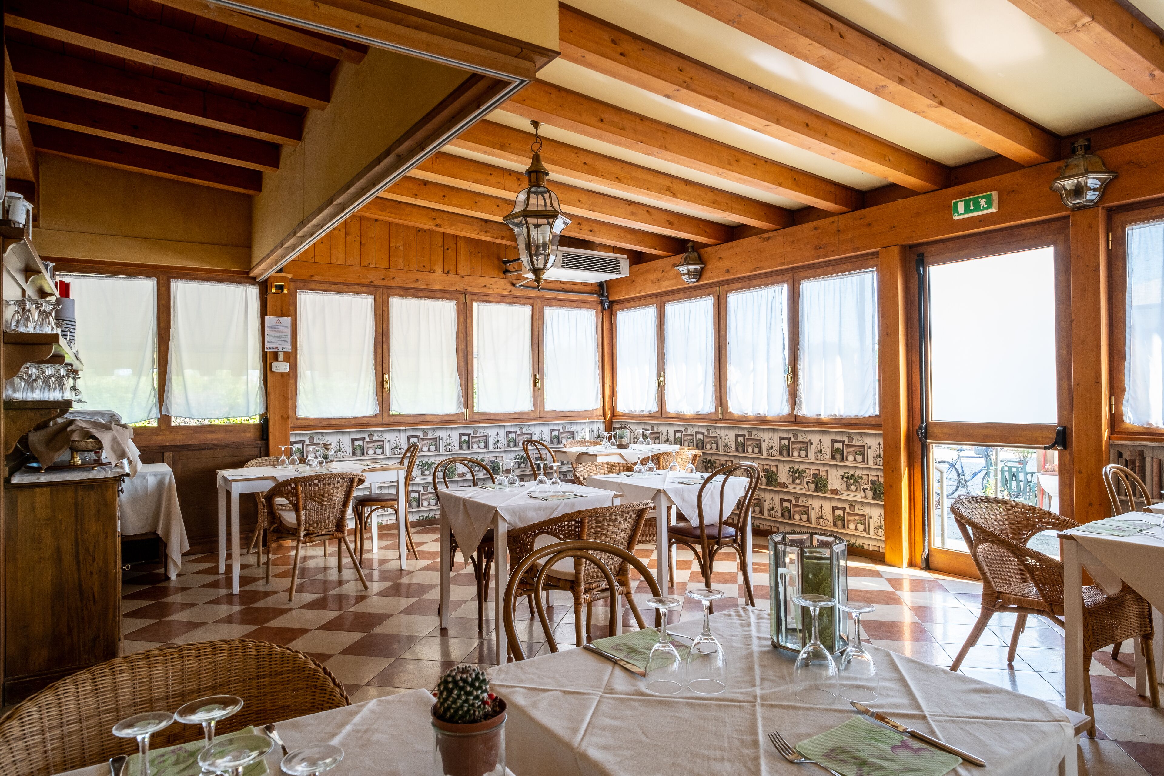 Ein Restaurant mit Holzbalken, einem karierten Boden und gedeckten Tischen.