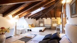 Un dormitorio con techo inclinado, una cama, un escritorio y una silla.
