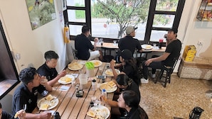 Un grupo de personas cenando en una mesa de madera con diversos platos y bebidas.