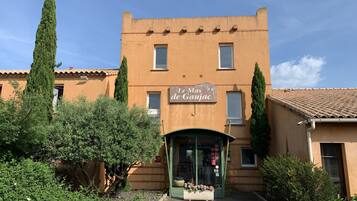Un bâtiment sur lequel on peut lire l’inscription « Le Mas de Gaujac », avec une porte d’entrée verte.