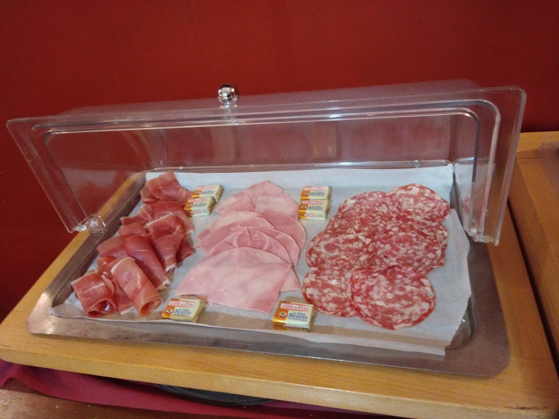 Une vitrine contenant différents types de charcuteries et de fromages.