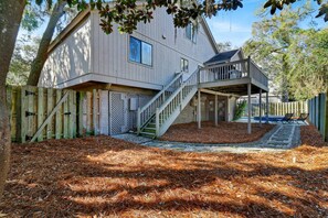 A two-story house with a covered porch and a staircase leading to the upper level.