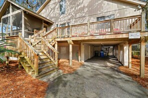 Un bâtiment à deux étages avec un escalier en bois menant à un porche abrité.