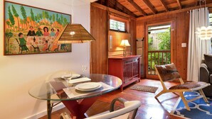 A dining area with a glass table, chairs, and a painting on the wall. - ~ SOLARIS PAIR-A-DISE ~ A garden lover’s dream on a quiet Key West lane. (Key West)