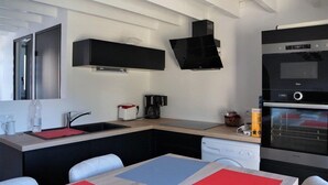 Una cuina moderna amb forn integrat, cafetera i rentaplats.