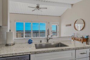 A kitchen with a large window, a ceiling fan, and a sink. - Oceanfront with stunning views.  (San Diego)