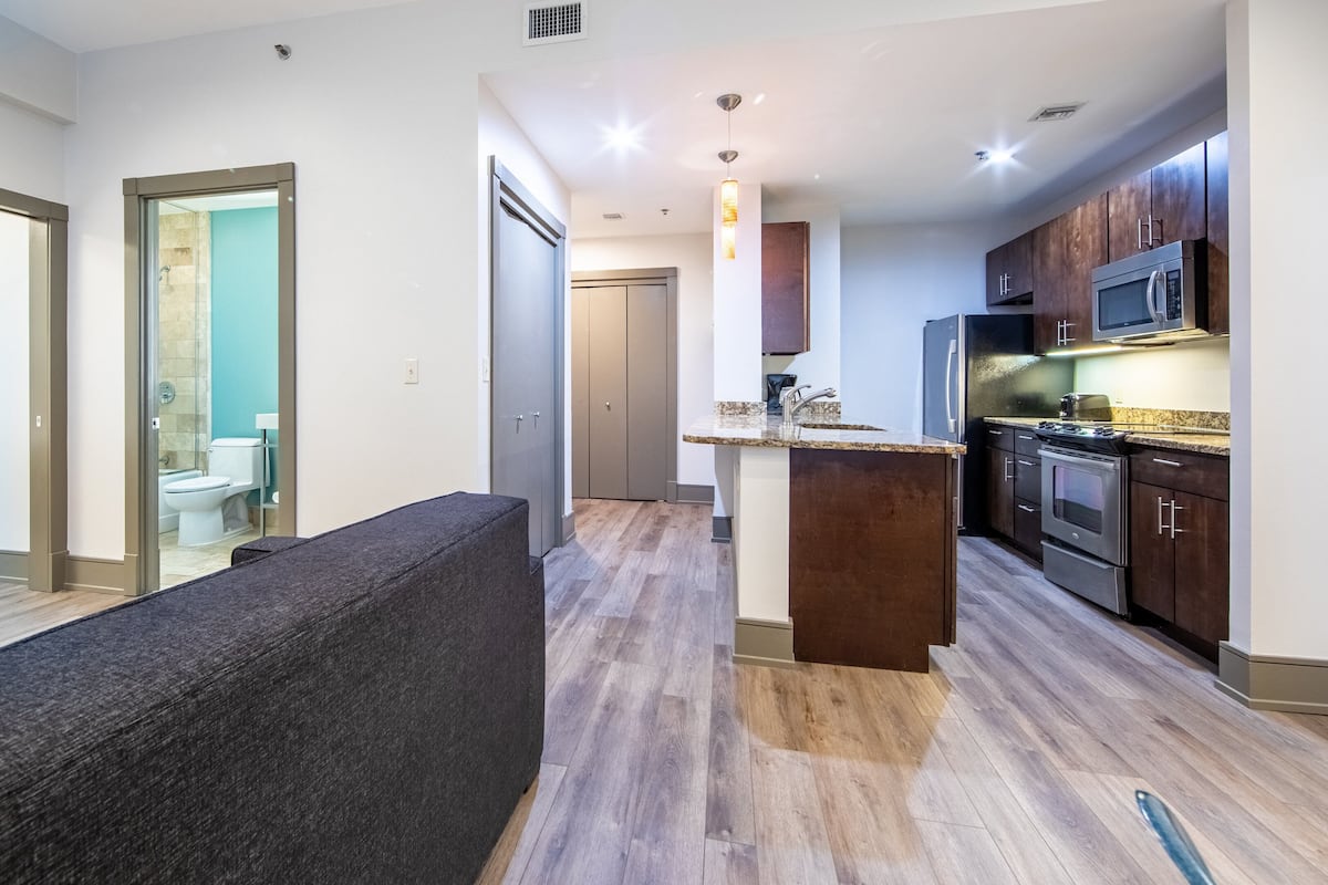 Un appartement moderne comprenant un espace de vie, une kitchenette et une salle de bain.