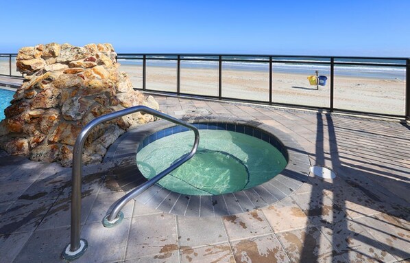 Relax by the pool overlooking the beach, with a clear view of the ocean.