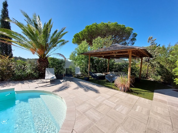 A pool area with a pergola, lounge chairs, and a palm tree. - VILLA LES ISSAMBRES GULF OF ST TROPEZ 1KM FROM THE SEA (Les Issambres)