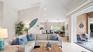 A modern living room with a sofa, coffee table, and dining area.
