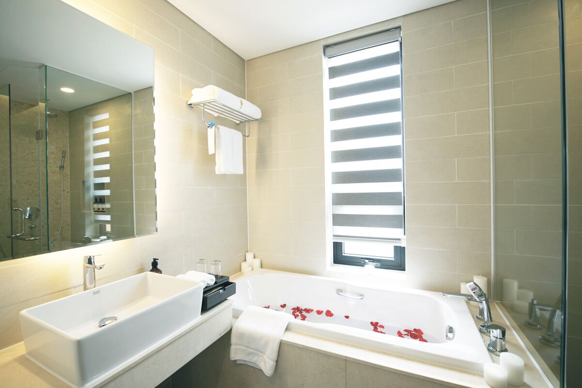 Un baño moderno con una bañera grande, un lavamanos independiente y una ducha a ras de suelo.