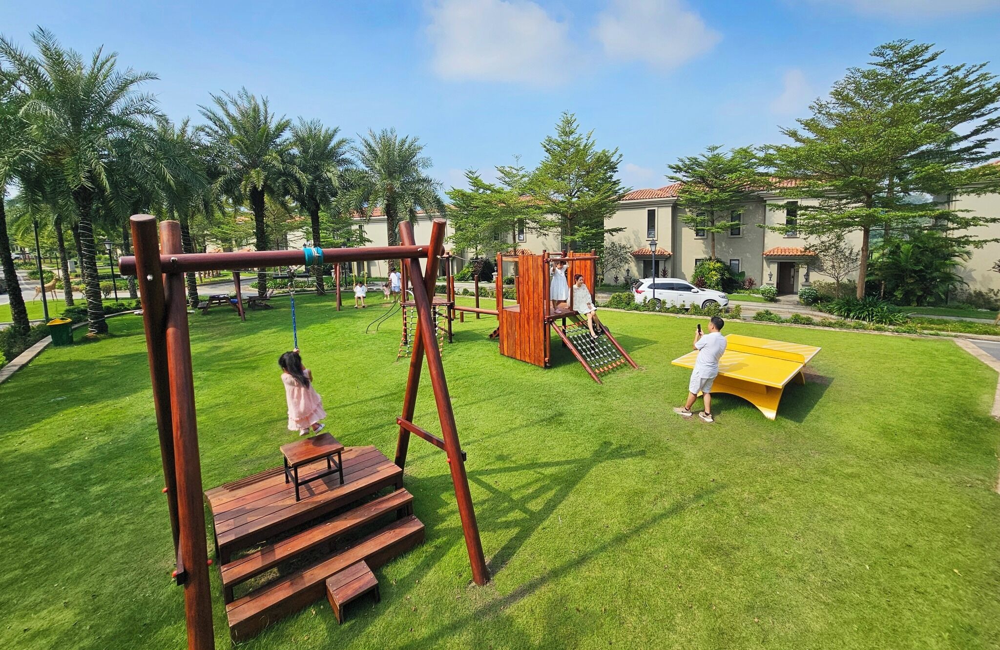 A playground with swings, a slide, and a picnic table.