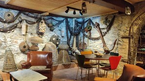A cozy room with a stone wall, a wooden ceiling, and a table with chairs. - Comfortable Fisherman's House (Llançà)