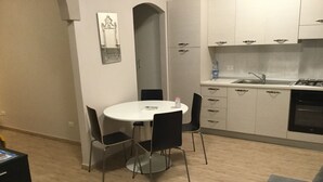 A compact living space with a dining area, kitchenette, and a sofa. - Open space apartment (Licata)