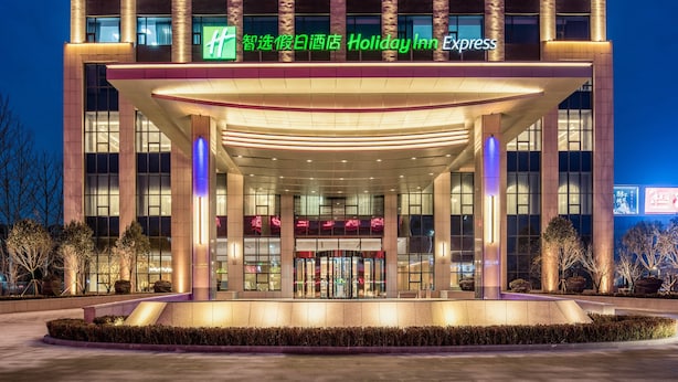 A Holiday Inn Express hotel entrance with a modern design, featuring a covered entrance area and illuminated signage. - Holiday Inn Express Liaocheng Chiping by IHG (Liaocheng)