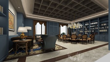 A spacious living room with a high ceiling, a dining area with a chandelier, and a bookshelf filled with books.