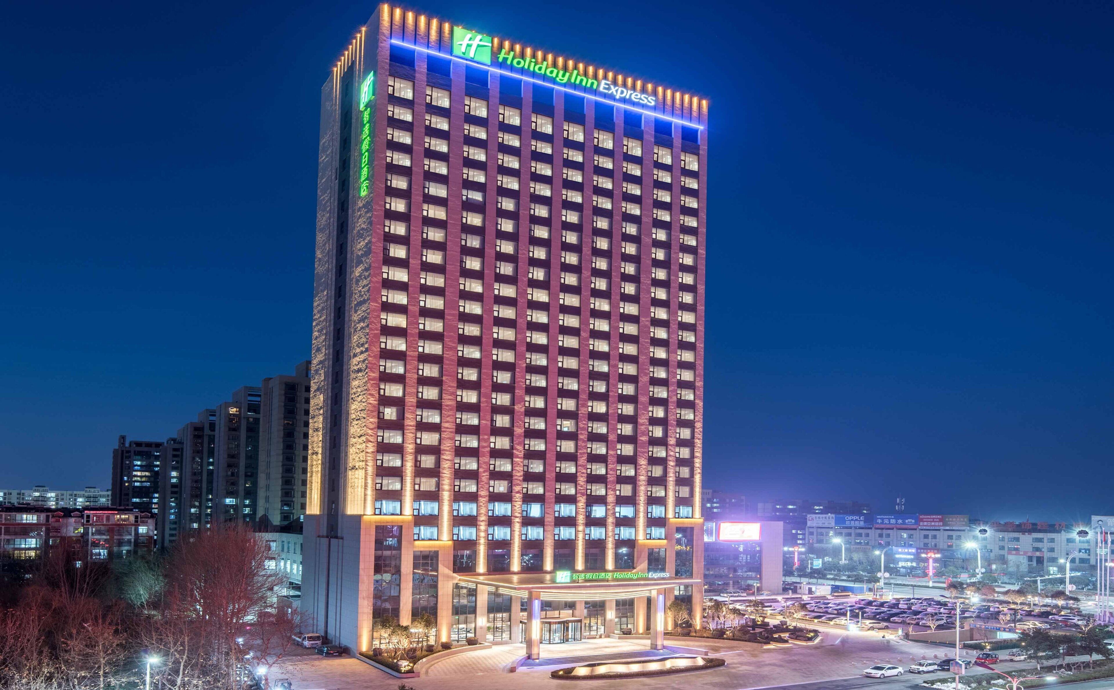 Un hôtel à plusieurs étages, sur lequel on peut voir, en haut, une grande enseigne distinctive de la chaîne Holiday Inn Express.