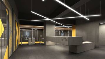 Interior moderno de gimnasio con iluminación geométrica, recepción de hormigón y detalles de diseño industrial.