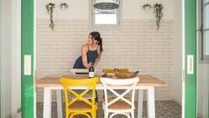 Un espace repas avec un mur en briques, un luminaire suspendu et des plantes en pot.