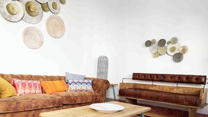 Un salon avec un canapé marron, une table basse en bois et un banc en cuir.