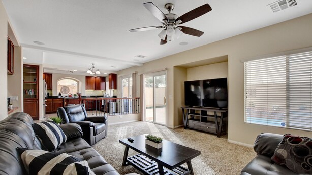 A spacious living room with a dark-colored sofa set, a coffee table, and a ceiling fan. - Pool/Spa-15 min from ✈️ & strip. Smart TVs Close to shopping 🍔 freeway... (Henderson)