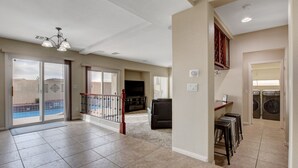 A spacious living area with a balcony, a fireplace, and a laundry room. - Pool/Spa-15 min from ✈️ & strip. Smart TVs Close to shopping 🍔 freeway... (Henderson)