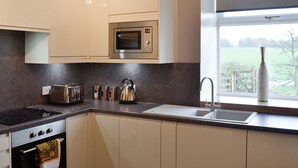 A modern kitchen with a built-in microwave, gas stove, and stainless steel appliances. - 4 bedroom accommodation in Fenwick, near Kilmarnock (Fenwick, near Kilmarnock)