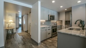 A modern kitchen with grey cabinets, a stainless steel microwave, and a built-in oven. - Decatur 1782 (Keystone)