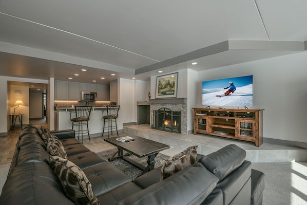 A modern living room with a fireplace, a television, and a sofa.