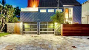 A modern house with a garage, a stone wall, and a wooden fence. - Surfrider at the Del Mar Beach Colony (Del Mar)