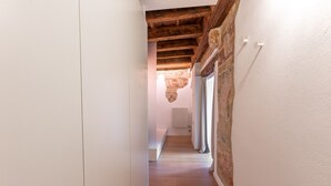 A narrow hallway with wooden beams and a radiator on the wall.