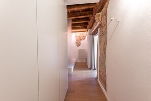 A narrow hallway with wooden beams and a radiator on the wall.