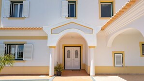 A two-story building with a central entrance, white walls, and yellow trim. - Stunning private villa for 11 people with private pool, A/C, WIFI, TV and terrace (Galé)