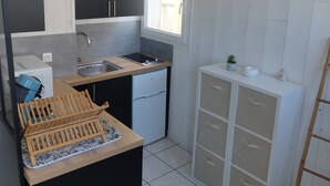 A compact kitchen with a sink, a small refrigerator, and a wooden rack. - Charming T1 Bis 50m from the Beach and the Market (Pornichet)