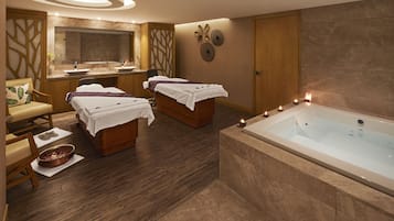 Relax in a serene spa room with a bathtub, two massage tables, and a vanity for personal grooming.