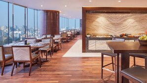 Ein modernes Restaurant mit Stadtblick, Holzböden und einer Marmorplatte.