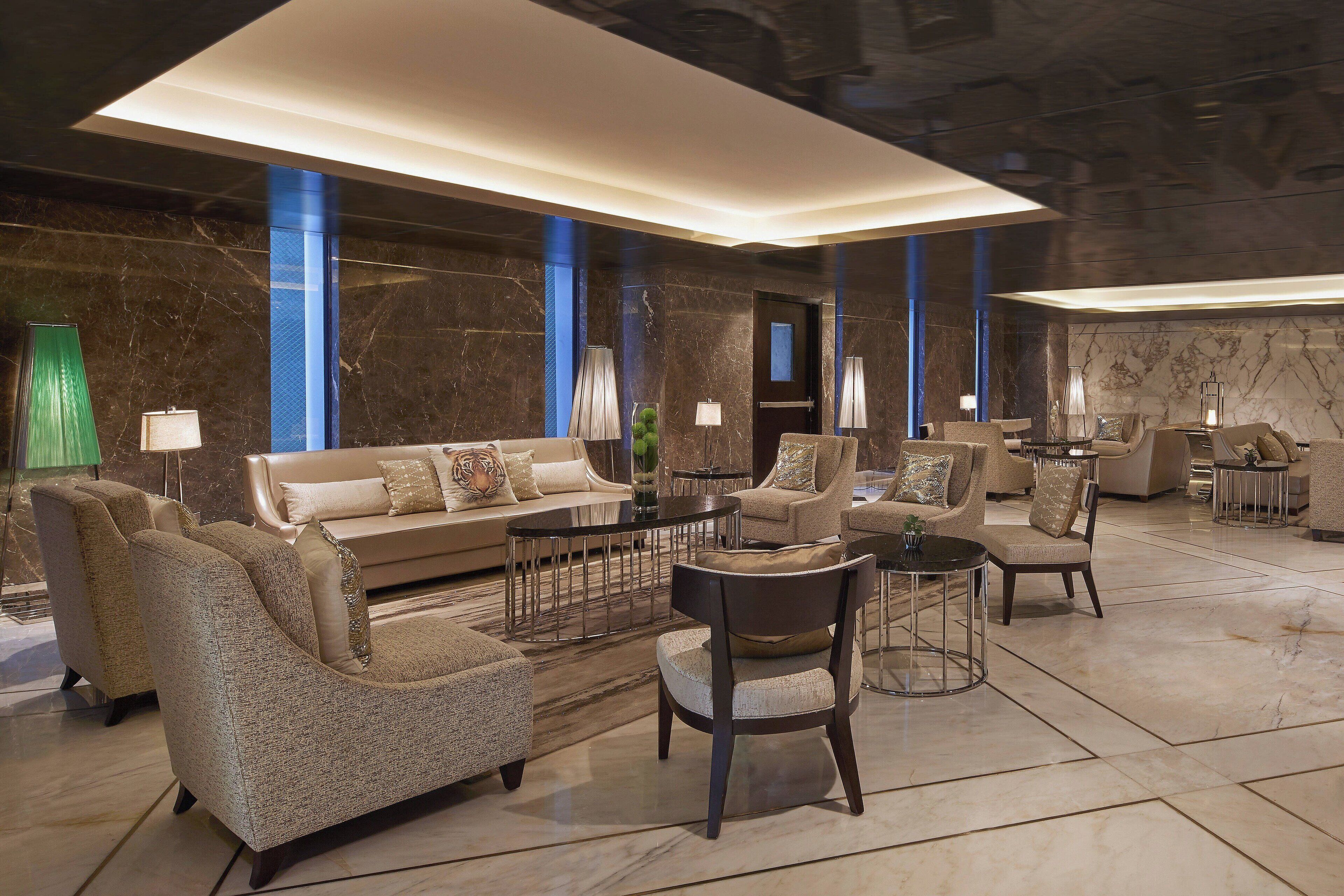 A spacious lobby with a sofa set, armchairs, and a coffee table.