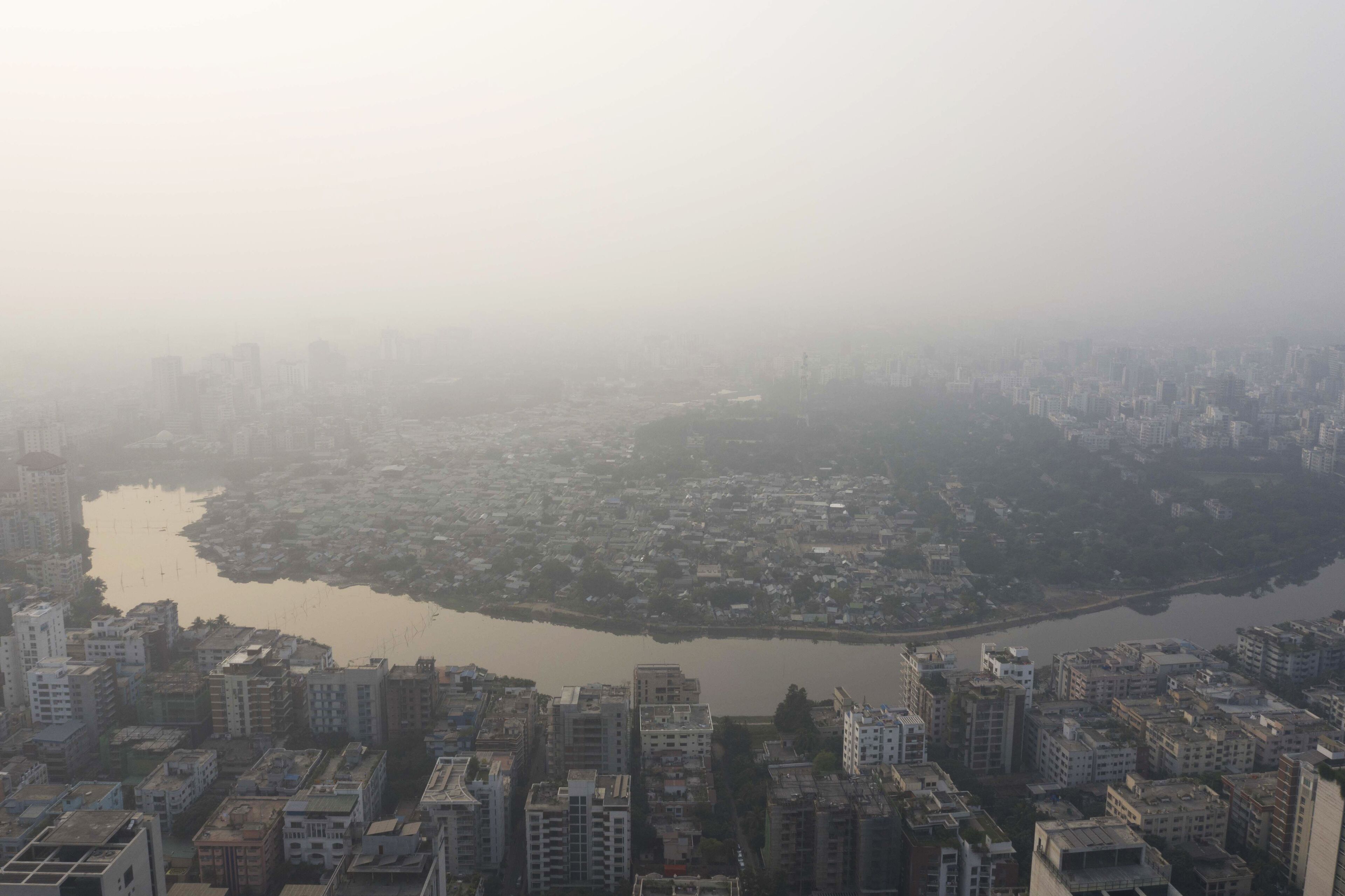 A cityscape with a river in the center, surrounded by dense urban buildings.