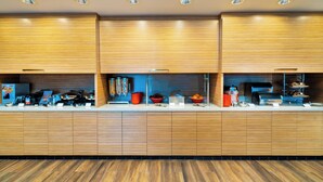 Une cuisine moderne avec des meubles en bois, une machine à café et divers produits alimentaires disposés sur le plan de travail.