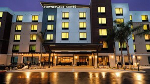 Un hôtel au design moderne, de la chaîne « Towneplace Suites », doté d’une entrée abritée et d’un espace extérieur aménagé pour se détendre.