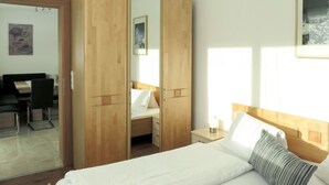 A bedroom with a bed, a wooden wardrobe, a desk, and a chair. - Beautiful apartment for 4 people with WIFI, TV and terrace (Ramsau Im Zillertal)