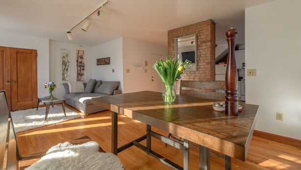 A modern living room with a wooden dining table, a sofa, and a coffee table.