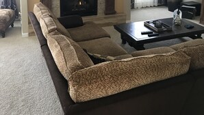 A living room with a fireplace, a sectional sofa, a coffee table, and a large vase. - A Spacious Home With Great Views & Wildlife (Parker)