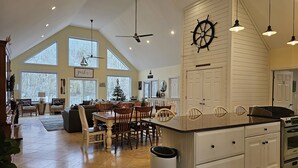A spacious kitchen with a large island, white cabinetry, and a sail wheel decoration. - Welcome to Hidden Haven – A Spacious Lakeside Retreat (Burnside)