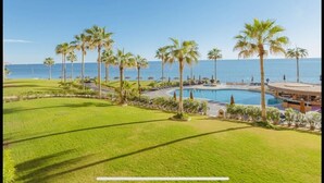 Un complex turístic amb piscina, palmeres i vistes a l'oceà.