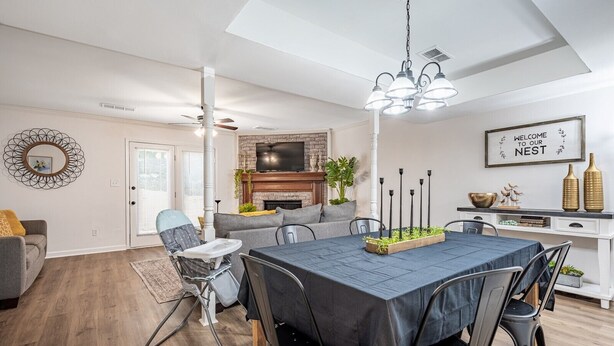 Una sala moderna con comedor, chimenea y televisor.